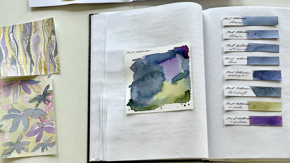 Notitzbuch mit Teststreifen von verschiedenen Pflanzentinten in blau Lila und grün. Daneben Zeichnungen mit den Tinten.
