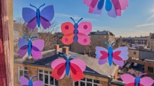 Frühlingsfrohe Papierschmetteringe und Blumen