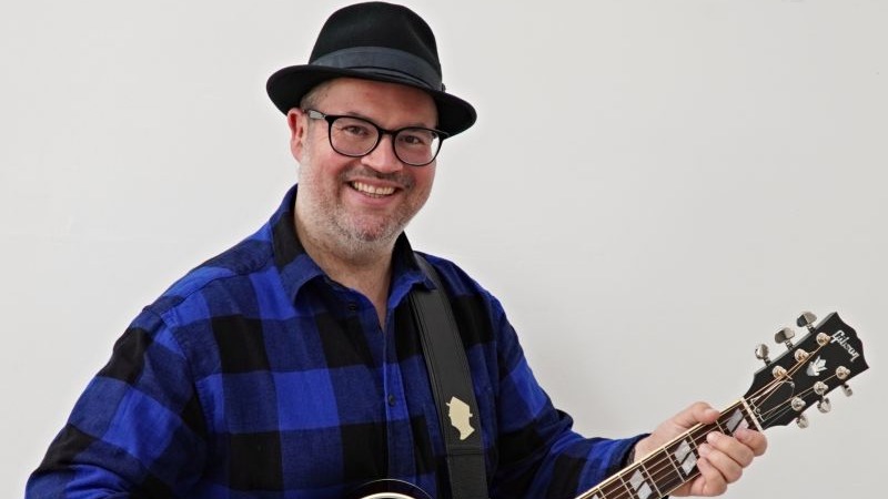 Musiker Björn Heuser mit Gitarre