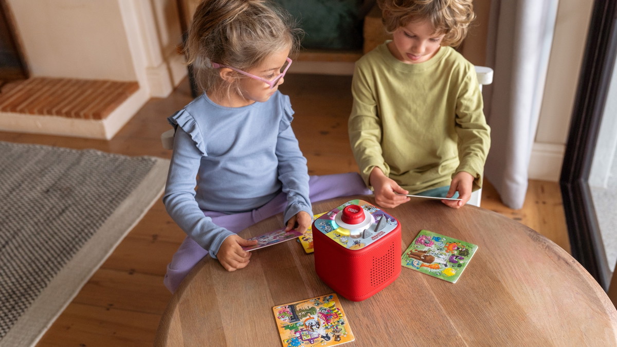 Zwei Kinder, die mit einer roten Toniebox 2 spielen.